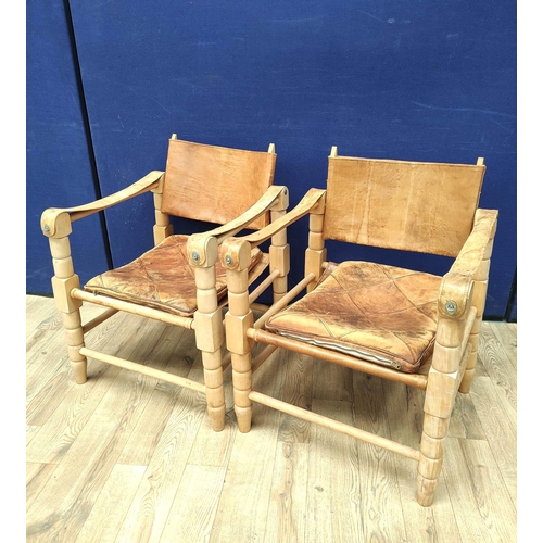 388 - Pair of 20th century Indian easy chairs of teak construction with stretched leather back and arm res... 