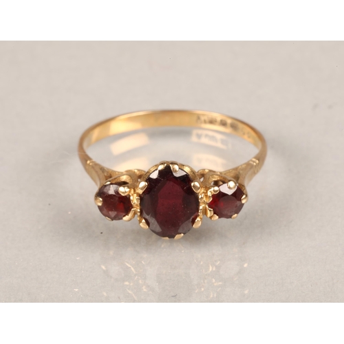 66 - 9ct yellow gold ring set with three red stones. Size: O