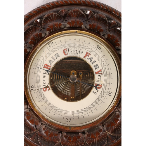 16 - Brass-cased bulkhead barometer, 14cm, and another with carved mahogany mount.  (2)