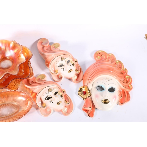 93 - Eight pieces of Carnival glass and a set of three graduated ceramic wall masks.