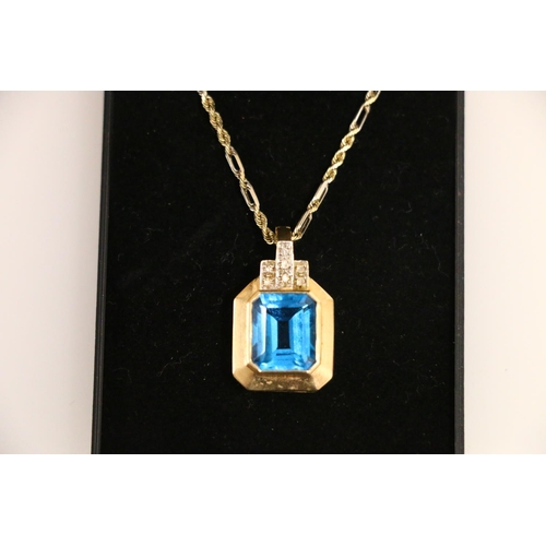 133 - 14ct gold pendant set with a vibrant blue rectangle cut stone, on 14ct gold chain 23cm, 11.4g.