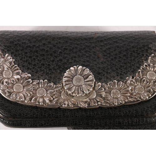 138 - Silver-mounted black seal leather purse by Tiffany & Co., the flap applied with silver daisies, ... 