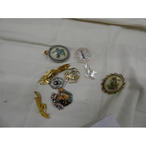 215 - Small bag of vintage brooches.