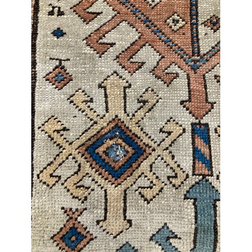 813 - Caucasian runner with hooked medallions within geometric borders, 470 x 110cm.