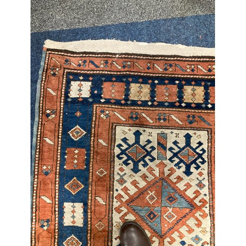 813 - Caucasian runner with hooked medallions within geometric borders, 470 x 110cm.