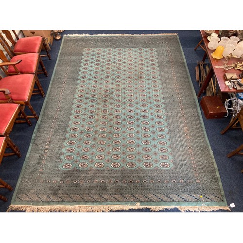 817 - Green Bokhara rug with gul motif to field within multiple borders, 350 x 250cm.