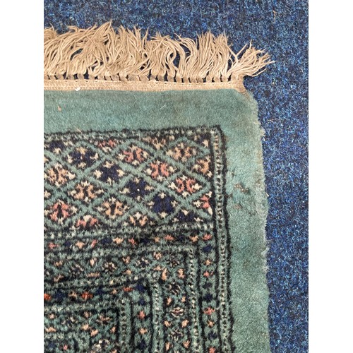 817 - Green Bokhara rug with gul motif to field within multiple borders, 350 x 250cm.