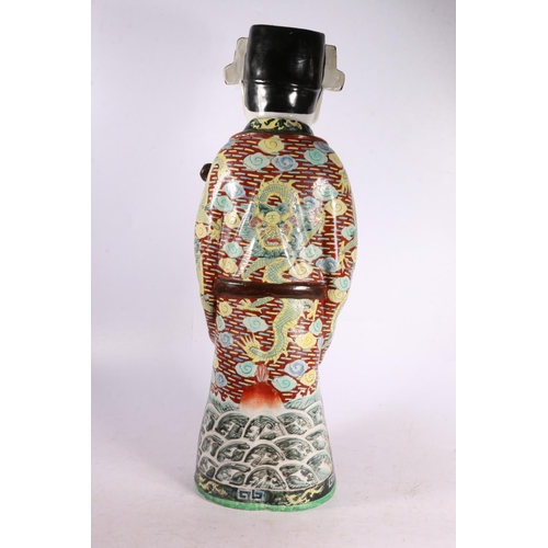 328 - Chinese pottery figure of a gentleman wearing a dragon decorated robe and holding a staff.