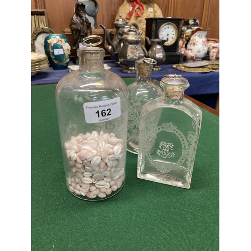 162 - Three etched glass bottles, one with quantity of shells, 19cm. 