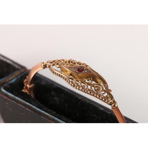 557 - Victorian 9ct gold bangle set with rubies and diamonds, makers D&C, 7.7g gross.