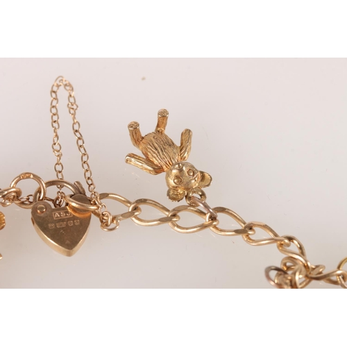 607 - 9ct gold charm bracelet with yellow metal charms, 15.9g. 