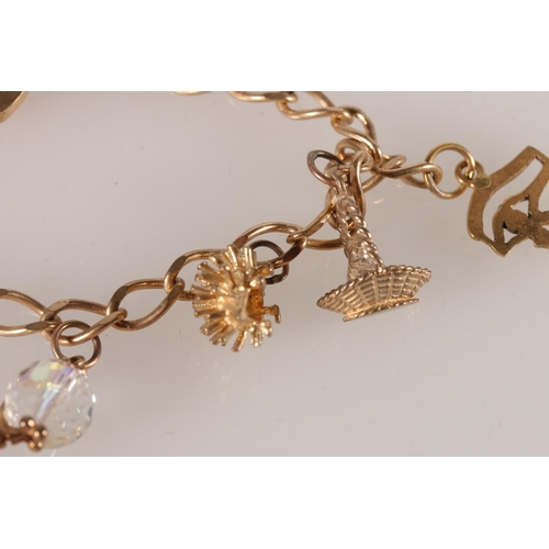 607 - 9ct gold charm bracelet with yellow metal charms, 15.9g. 