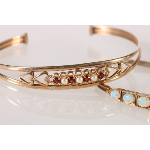 624 - Yellow metal hinged bracelet with 9 graduated opals, 16cm, another open bangle, and a 1/5th rolled g... 