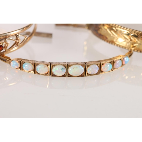 624 - Yellow metal hinged bracelet with 9 graduated opals, 16cm, another open bangle, and a 1/5th rolled g... 