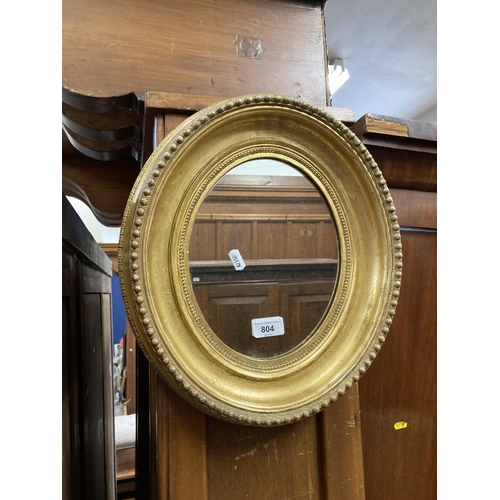 804 - Oval wall mirror with moulded gilt frame, 40 x 34cm.