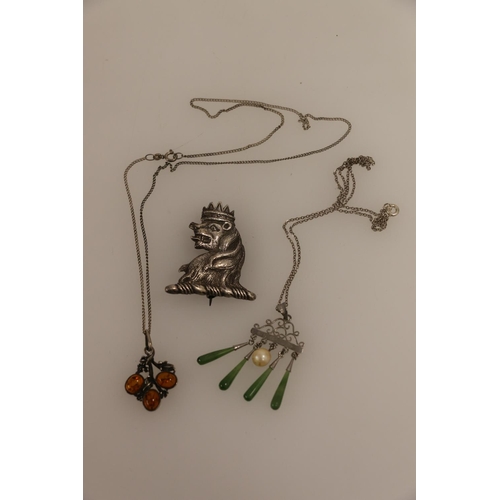 504 - Silver and amber pendant on chain, a silver and green hardstone pendant on chain, and a white metal ... 