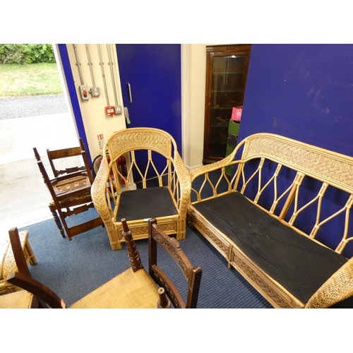 517 - Large cane conservatory suite comprising two seater sofa, chair and table.