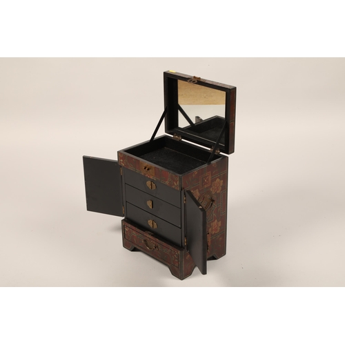 492 - An oriental lacquered table cabinet, hinged cover over pair of decorated doors, enclosing three draw... 