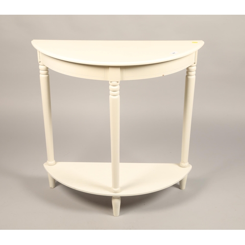 497 - White painted demi lune two tier hall table, 78cm diameter