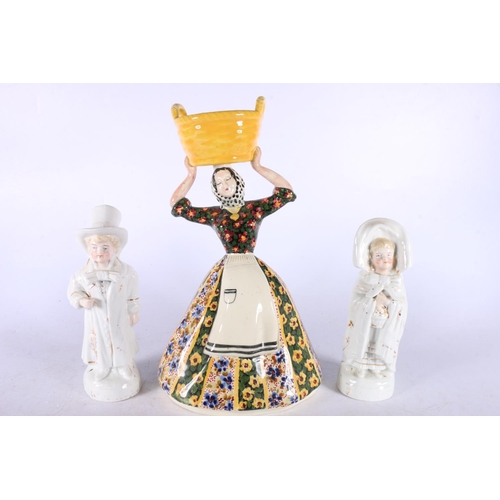 59 - Portuguese pottery figure modelled as a washerwoman holding a basket on head, 25cm high, and a pair ... 