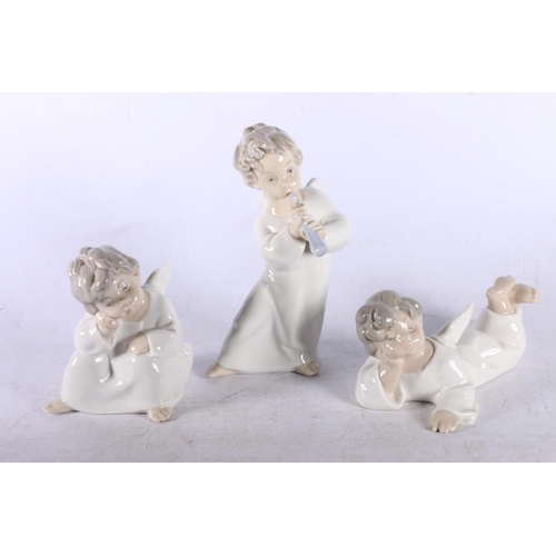 160 - Three Lladro angels, Angel with flute boxed and two others.