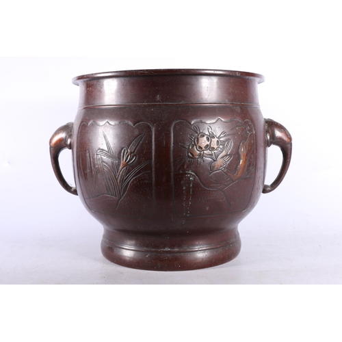 264A - Oriental bronzed metal twin-handled jardinière, decorated with elephant mask handles and four... 