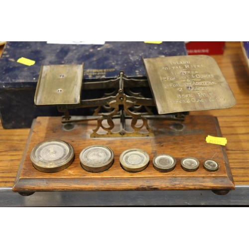 219 - Vintage postal scales inscribed inland postal rates, etc., with weights, and vintage tins.