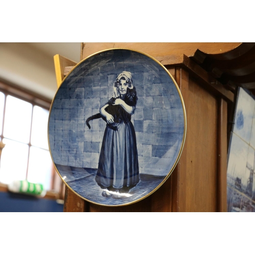 260 - B K B Dutch blue and white porcelain wall charger, with scene of a girl holding a cat, after P Hoeck... 