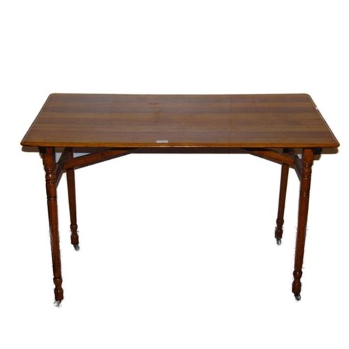 356 - Ash and oak trestle-style folding table, the rectangular top on turned supports and castors united b... 