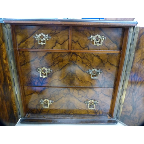 127 - Burr walnut apprentice cabinet with carry handles and doors enclosing fitted drawers.