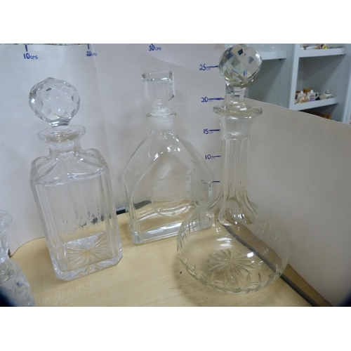 220 - Three glass decanters, cut glass candlesticks, paperweight and a glass dish.