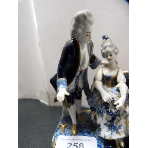 256 - Continental porcelain figure group modelled as a tea party, glazed in blue, white and gilt.