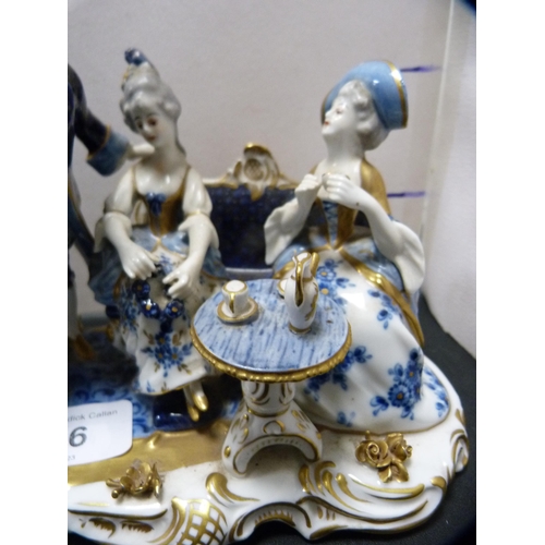 256 - Continental porcelain figure group modelled as a tea party, glazed in blue, white and gilt.