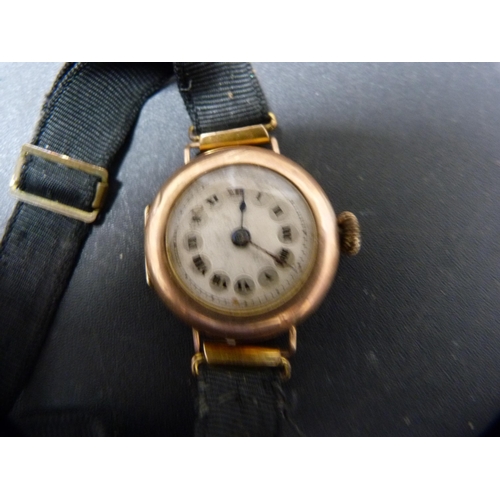 297 - Antique lady's 9ct gold-backed wristwatch on a cloth strap, 15g gross.