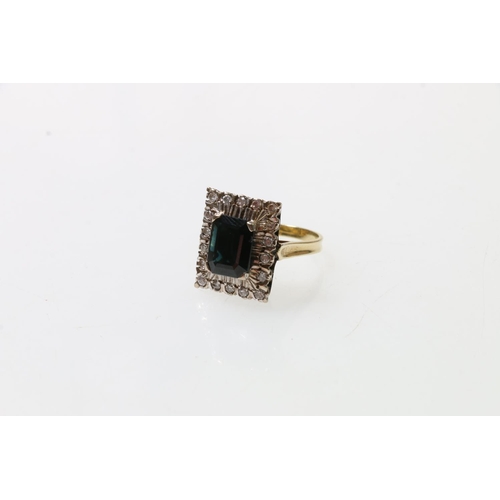 168 - 18ct gold diamond ring set with central baguette cut deep blue stone, London, size O, 7.6g.