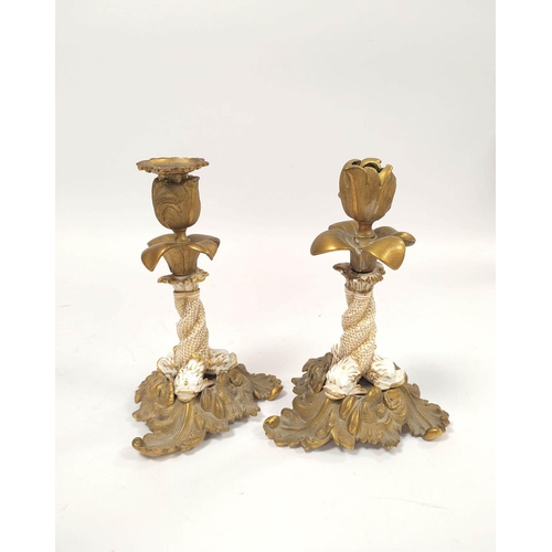 162 - Pair of 19th century brass candlesticks with relief tulip decoration to the sconce, white ceramic an... 