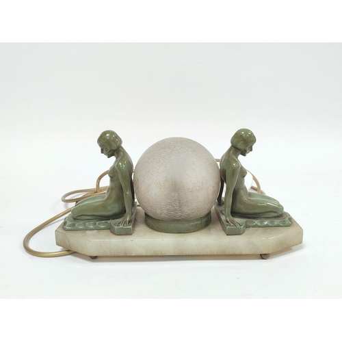 166 - Art Deco verdigris bronze table lamp modelled as opposing seated nude females with glass shade to th... 