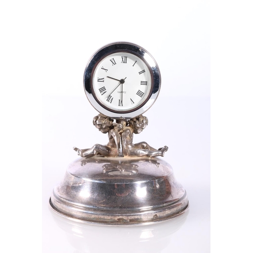 706 - Silver watch stand with cherub supporters. 