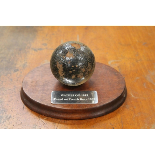 276 - Cast iron cannonball on plaque 'Waterloo 1815 found on the French Line'.