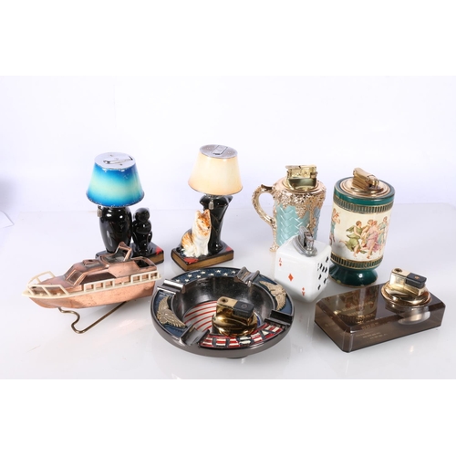 713 - Novelty cigarette lighters to include boat, dice, dog and cat lamp etc. 