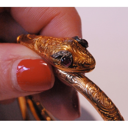 32 - Fine Victorian gold snake bangle, hinged in six sections, engraved with scrolls, the head with caboc... 