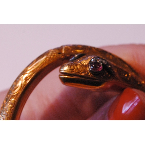 32 - Fine Victorian gold snake bangle, hinged in six sections, engraved with scrolls, the head with caboc... 