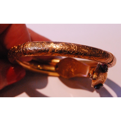 32 - Fine Victorian gold snake bangle, hinged in six sections, engraved with scrolls, the head with caboc... 