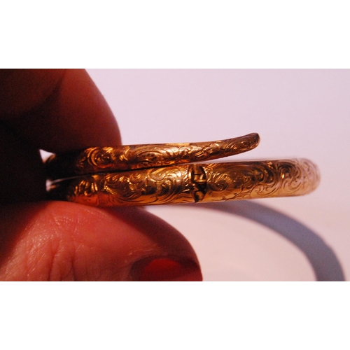 32 - Fine Victorian gold snake bangle, hinged in six sections, engraved with scrolls, the head with caboc... 