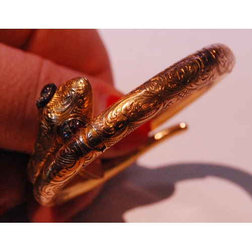 32 - Fine Victorian gold snake bangle, hinged in six sections, engraved with scrolls, the head with caboc... 