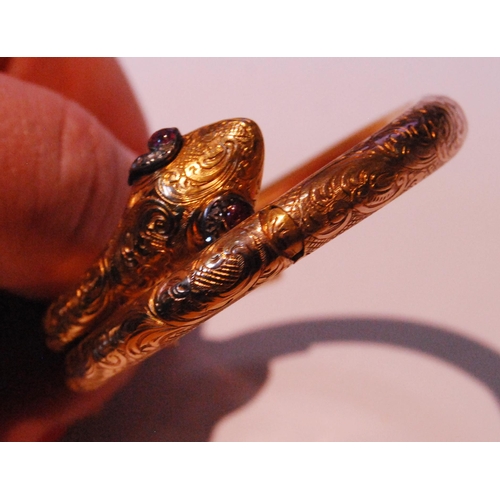 32 - Fine Victorian gold snake bangle, hinged in six sections, engraved with scrolls, the head with caboc... 