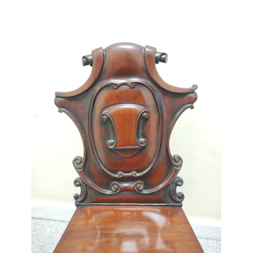 403 - Victorian mahogany hall chair with shaped scroll back bearing scroll cartouche to the centre, on spi... 