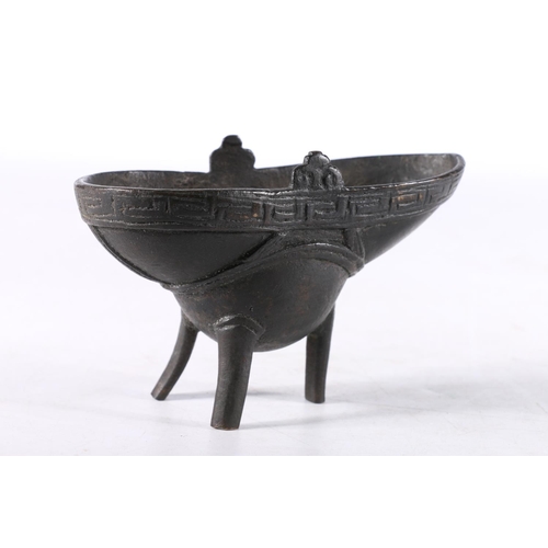 466 - Chinese cast bronze libation cup of typical form with Greek Key style border, raised on three suppor... 