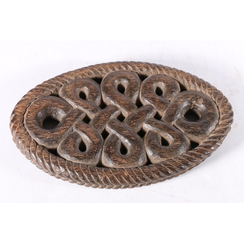 478 - Antique carved wood oval panel with continuous knot design, 19cm long.