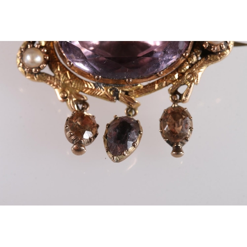 139 - Victorian yellow metal brooch, the central faceted oval amethyst encircled by two snakes guarding fo... 